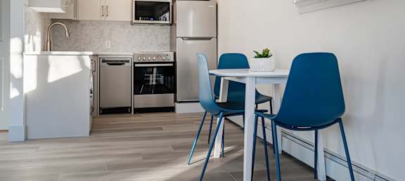A kitchen with a table and chairs.