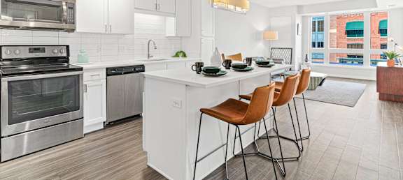 an open kitchen with a large island with four stools