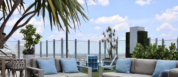 a patio with couches and tables on a roof top