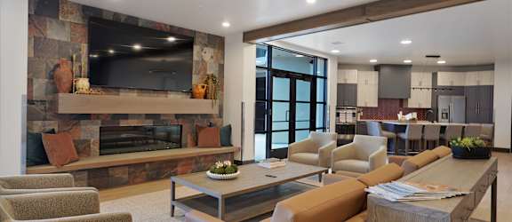 A modern living room with a stone fireplace and a large flat screen TV.
