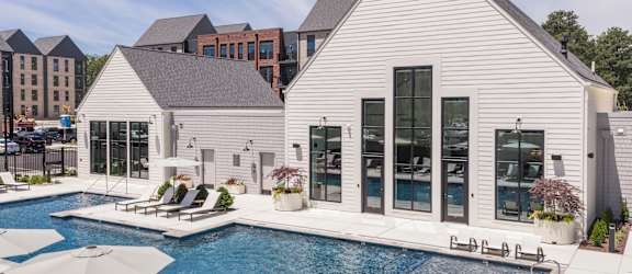 A white building with a pool in front.