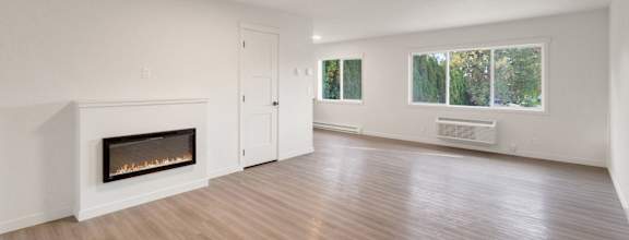 an empty living room with a fireplace and a window