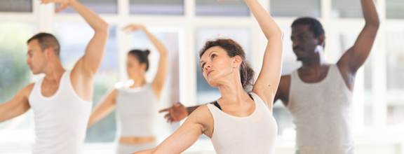 A group of people are practicing dance in a studio.