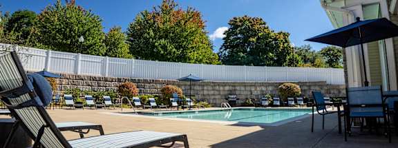 our resort style swimming pool is in front of our house with chairs and