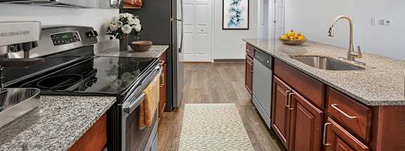 A kitchen with dark wood cabinets and granite countertops.