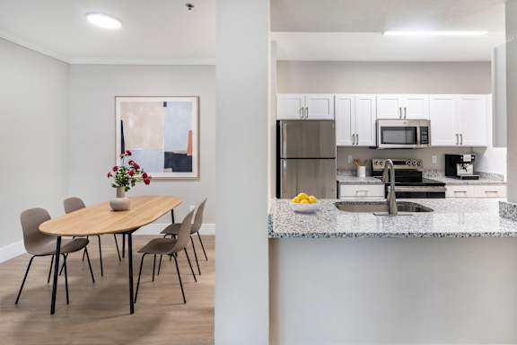 A modern kitchen with a dining table and chairs.