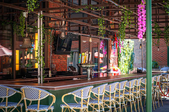 A restaurant with tables and chairs and hanging plants.