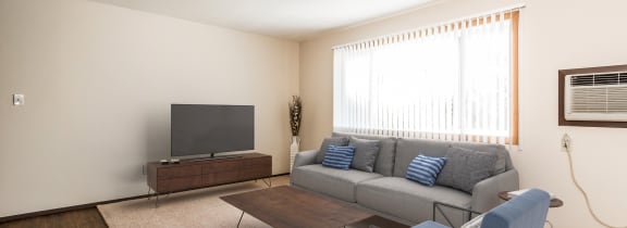 a living room with a couch and a chair and a television
