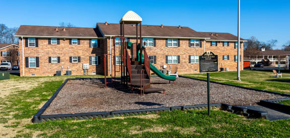 a playground in front of a brick building
