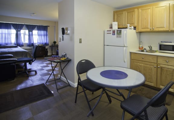 a kitchen and dining room with a table and chairs and a refrigerator
