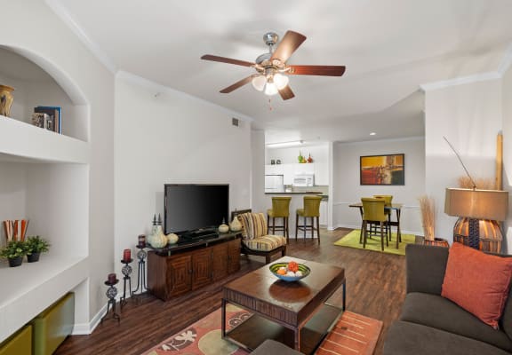 a living room with a ceiling fan and hardwood flooring