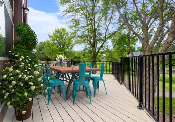 a patio with a table and chairs on a wooden deckat Millcreek Woods Apartments, Kansas, 66061