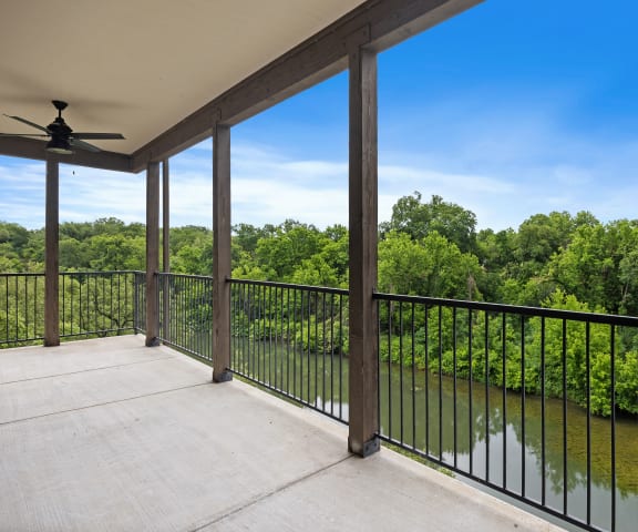 a balcony with a view of a river and trees