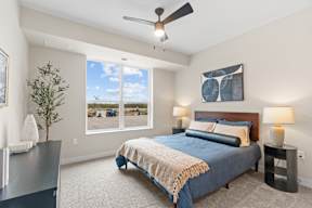 A bedroom with a large bed and a ceiling fan.