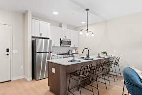 A modern kitchen with a large island and stainless steel appliances.