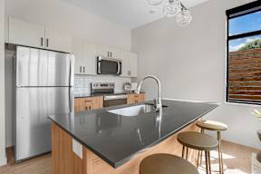 A modern kitchen with a large island and stainless steel appliances.