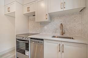 A kitchen with a stainless steel oven and sink.