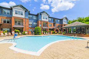 A swimming pool in front of a multi-story apartment building.