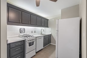 a kitchen with gray cabinets and white appliances