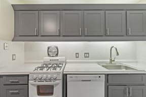 a kitchen with gray cabinets and white appliances