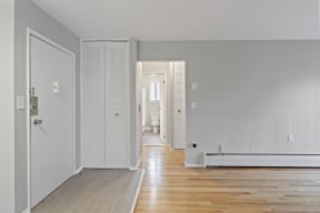 a bedroom with white walls and wood floors