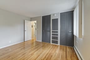 a bedroom with a wardrobe and hardwood floors