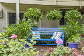 a blue bench with two pillows in a garden