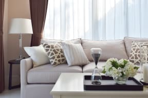 a living room with a couch and a table with a vase of flowers