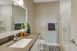 Master bathroom with tile shower and quartz countertops in 2 bedroom apartment for rent at Ascend at Woodbury best apartments Woodbury MN 55129