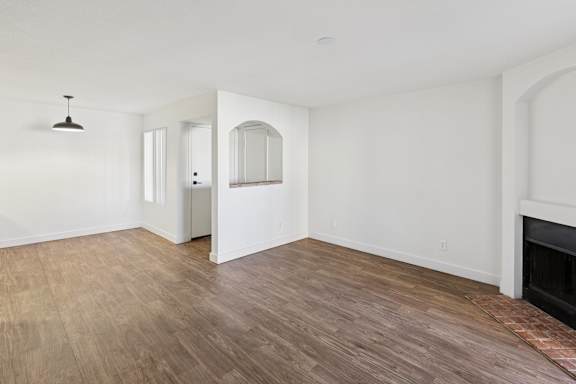 A room with a fireplace and wood flooring.