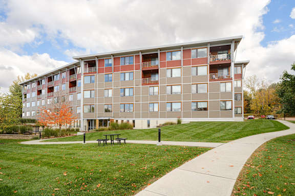A large apartment complex with a grassy area in front.