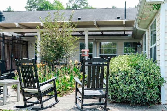 Two rocking chairs are on a patio.