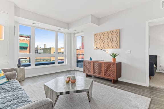a living room with a couch and a coffee table and large windows