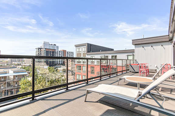 a balcony with a view of the city and a chair and a table