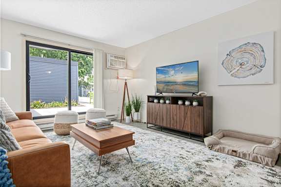 A living room with a television on a wooden stand at The Bosk Apartment Homes, Woodbury, MN, 55125