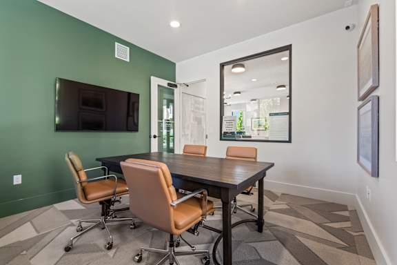 A conference room with a large table and chairs.