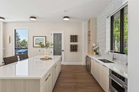 A modern kitchen with a white countertop and wooden cabinets.