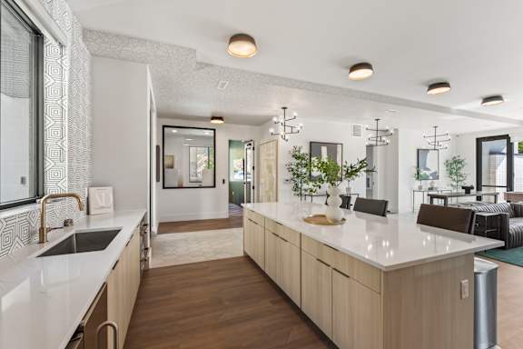 A modern kitchen with a white countertop and wooden cabinets.