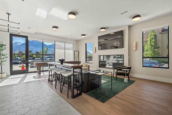 A modern living room with a bar area and a view of the mountains.