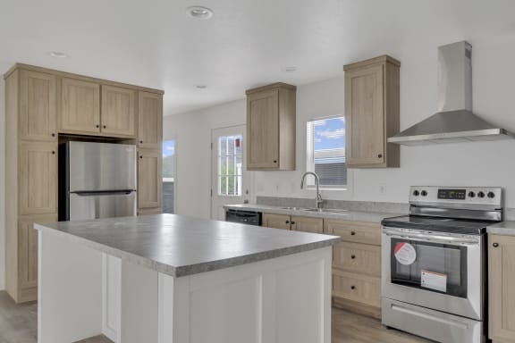 a kitchen with a large island and stainless steel appliances