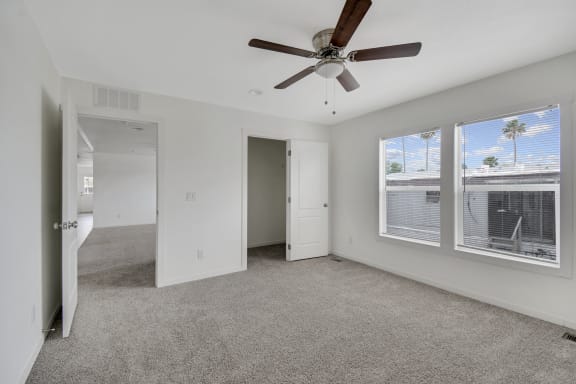 an empty bedroom with a ceiling fan