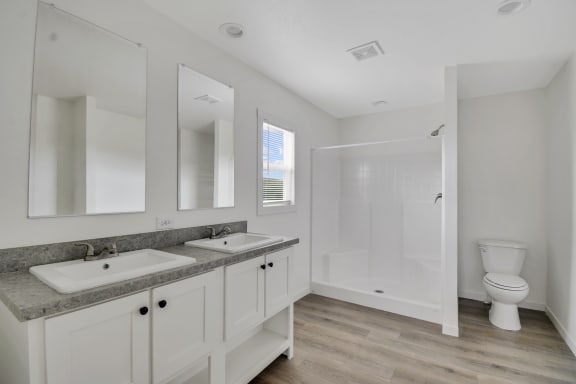 a bathroom with two sinks and a toilet