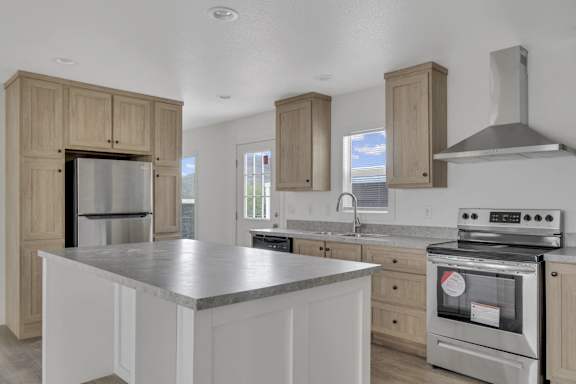 a kitchen with a large island and stainless steel appliances