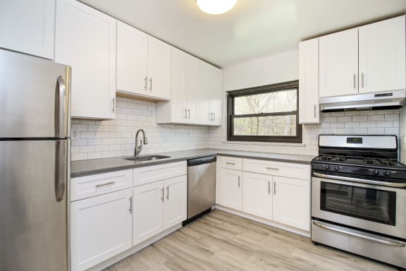 a kitchen with white cabinets and stainless steel appliances