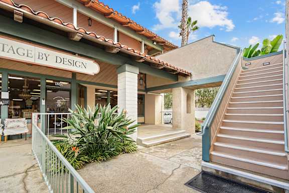 A storefront with the name "STAGE BY DESIGN" on the sign above the entrance.