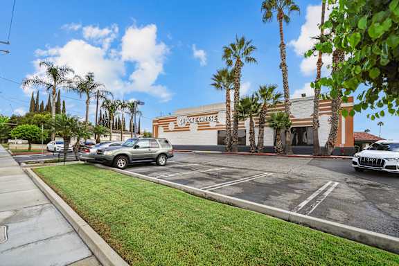 A Chick-fil-A restaurant is surrounded by palm trees.
