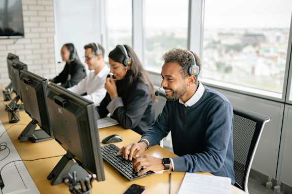 A group of people working on computers in an office.