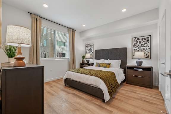 A bedroom with a large bed and a mirror on the wall.