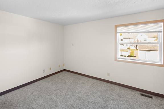 Empty room with a window showing a view of a street.