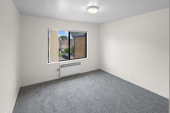 A room with a window and a radiator on the wall.